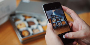 a person taking a photo of the cookies from his bakery for instagram